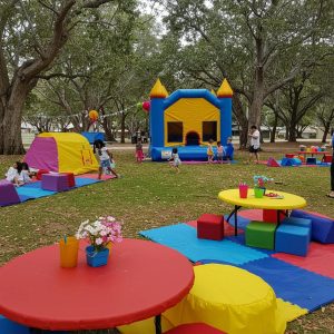 Colorful kids party setup with bounce house and children playing